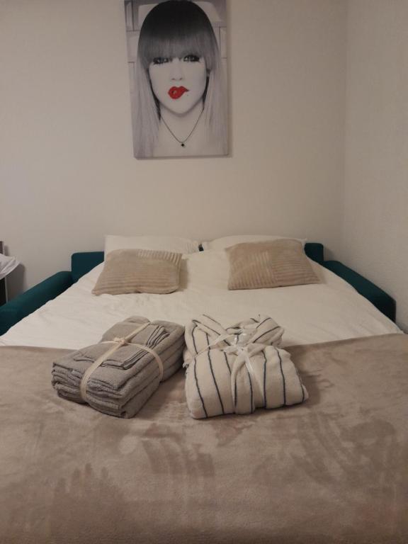 a bed with two towels on it with a picture on the wall at San's resort in Vionnaz