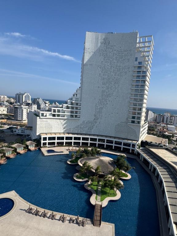 een groot gebouw met een zwembad ervoor bij Long Beach, İskele, Grand Sapphire Resort - Pool View Luxury Studio in Paralimni