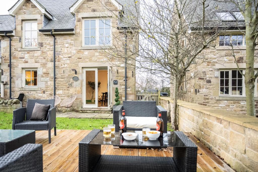 a patio with a table and chairs on a wooden deck at Northern Hideaways Apple Store, Ellingham in Chathill