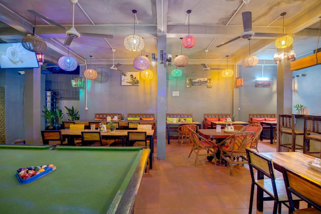 a pool table in a restaurant with tables and chairs at Siem Reap Pub Hostel in Siem Reap