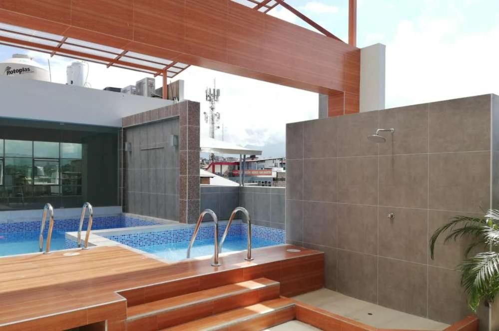 een badkamer met een bad en een zwembad bij Hotel Cerro Azul in La Merced