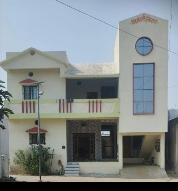 a building with a dog sitting in front of it at Hotel Pawar Palace Mahurgad in Māhūr