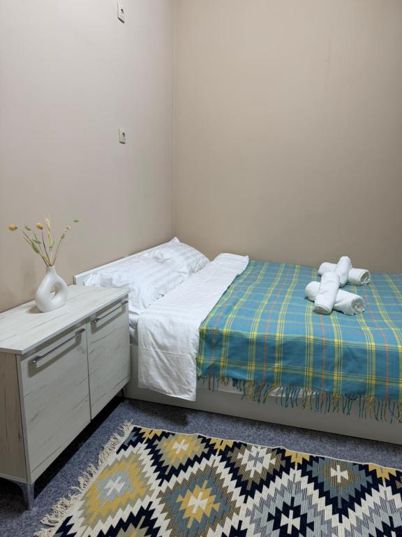 a bedroom with a bed with a teddy bear on it at Sky Tau Hostel in Almaty