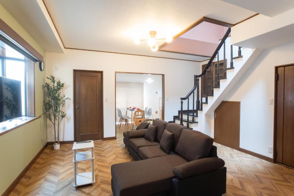 a living room with a couch and a staircase at Kotori Ayase in Tokyo