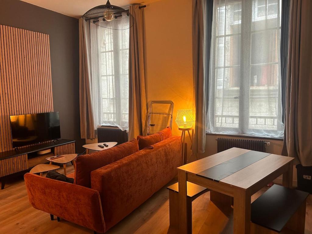 un salon avec un canapé et une table dans l'établissement le Limo: logement cosy en hyper centre, à Périgueux
