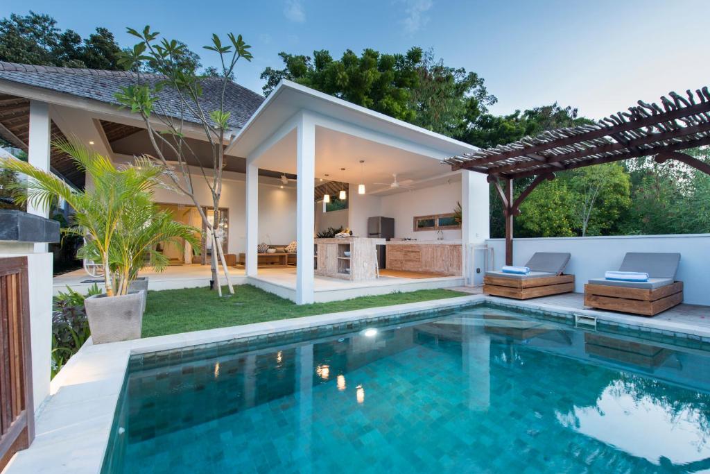 a villa with a swimming pool and a house at Tenang Villas in Nusa Lembongan