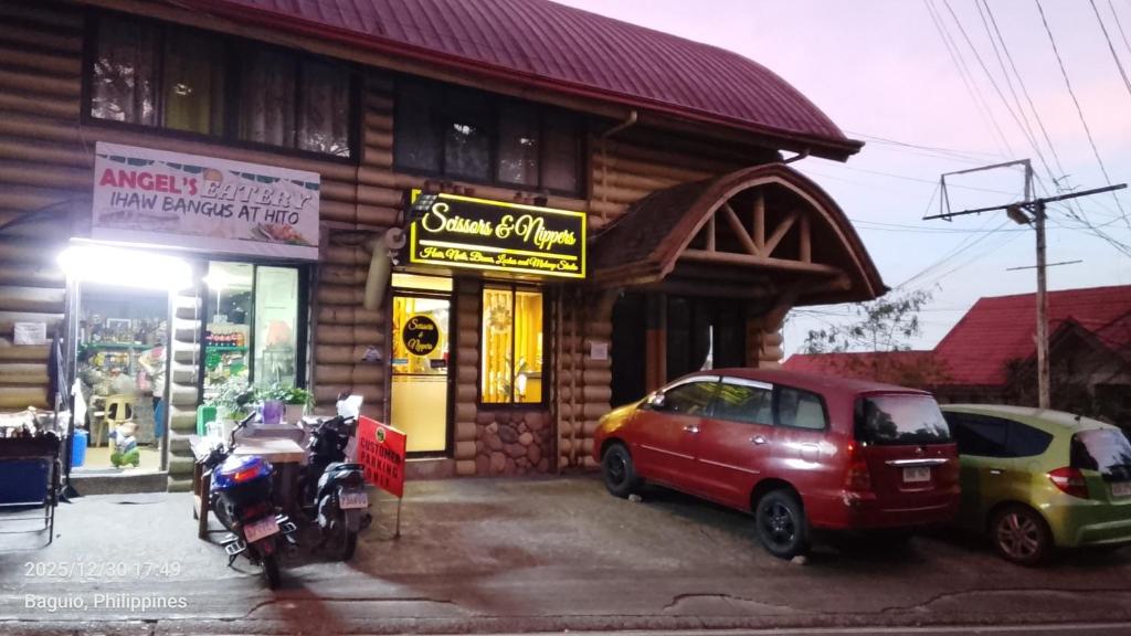 a building with a motorcycle parked in front of it at Ingeritch Cabin Transient and Homestay in Baguio