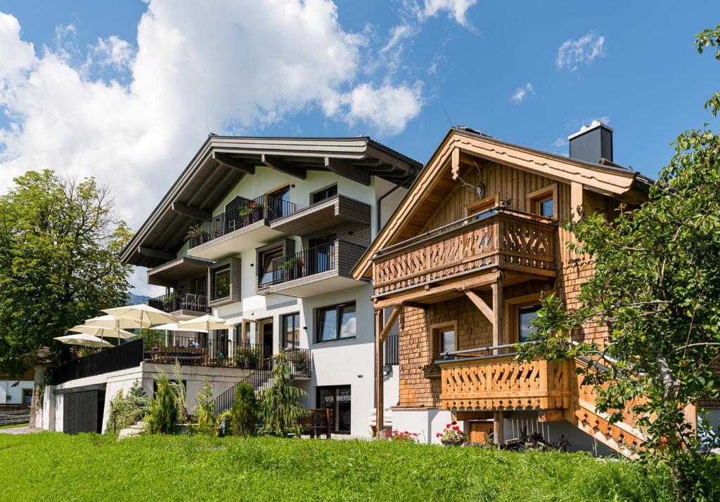 un immeuble d'appartements avec balcon sur une colline dans l'établissement Gasthof Hubertus, à Saalfelden