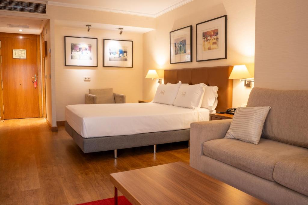 ein Hotelzimmer mit einem Bett und einer Couch in der Unterkunft Aparto-Hotel Rosales in Madrid