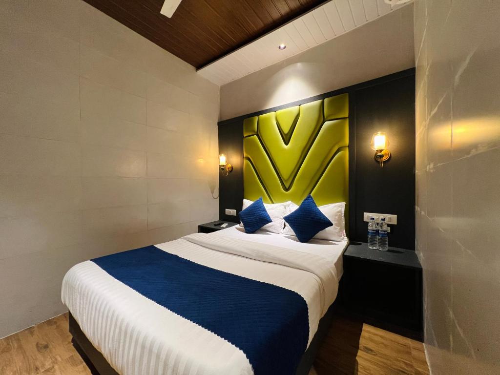 a hotel room with a large bed with blue pillows at Hotel Imperial Suite-Near BKC in Mumbai