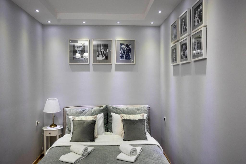een slaapkamer met een bed met vier foto's aan de muur bij Bed & Breakfast Garden40 in Belgrado