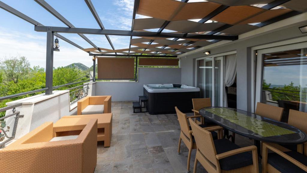 a patio with a table and chairs on a balcony at House Vidovic by Villas Guide in Mlinište