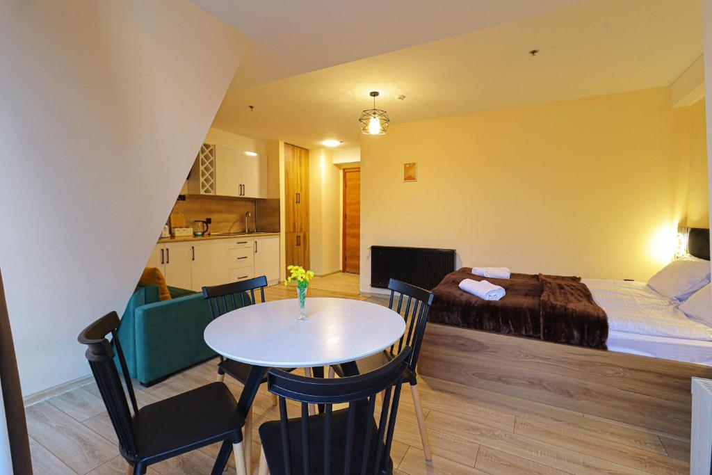 a room with a bed and a table and chairs at Comfy Studio in Gudauri Marshall - By Wehost in Gudauri