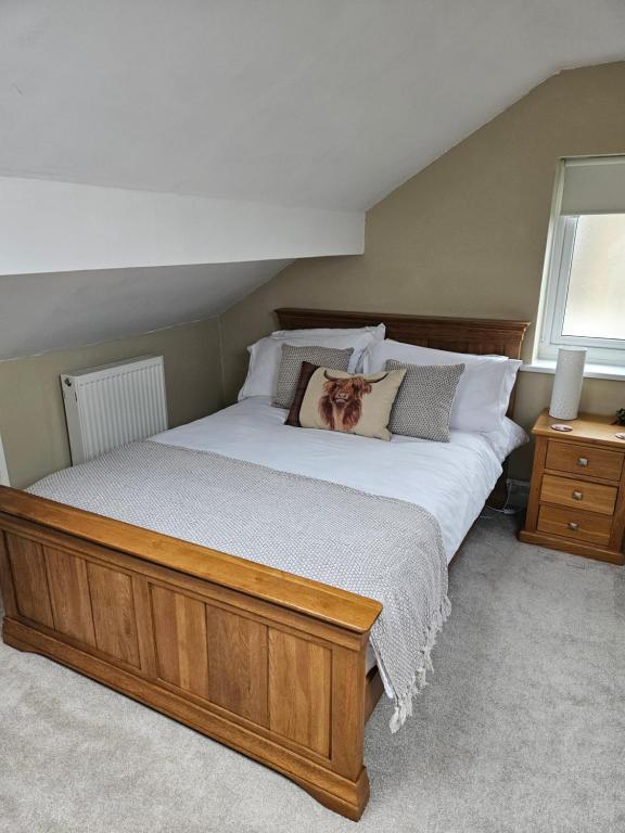 a bedroom with a large bed with a wooden frame at The Attic in Dove Holes