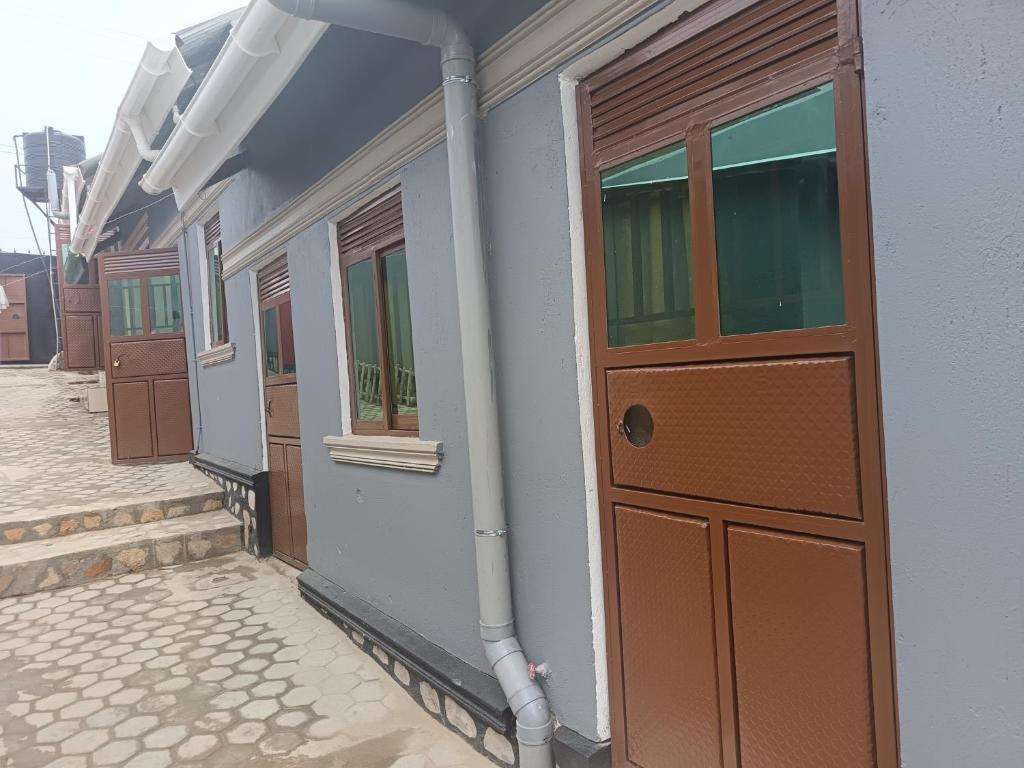 een gebouw met een bruine deur en een aantal ramen bij Delight motel in Ishaka