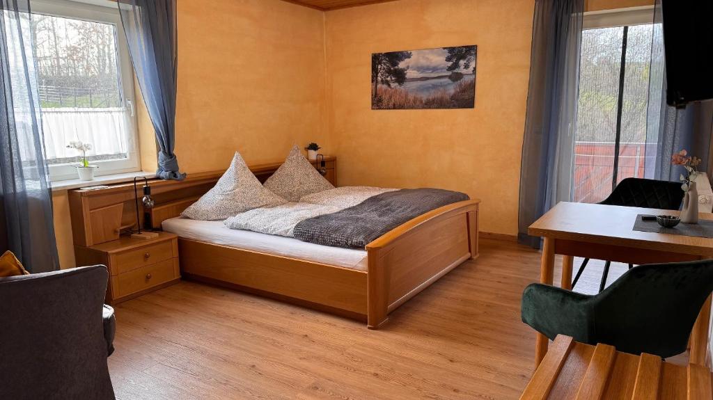 una camera da letto con un letto, una scrivania e due finestre di Haus am Heubach a Bad Staffelstein