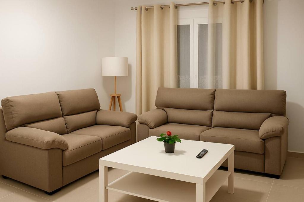 een woonkamer met twee banken en een salontafel bij Alojamiento Baeza California 4A in Baeza