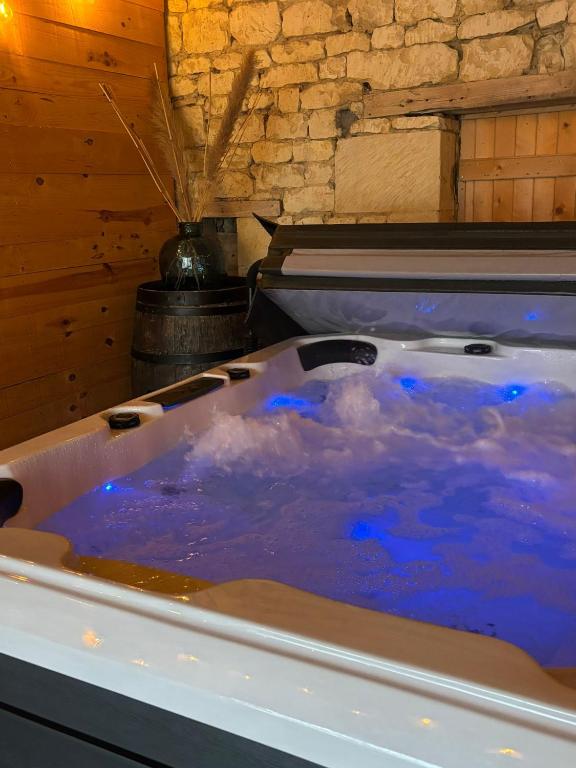 a bath tub filled with blue water in a room at La Douce Parenthèse in Loudun