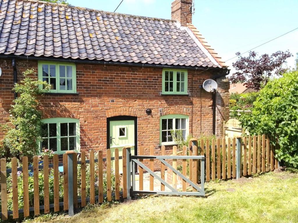 a brick house with a wooden fence in front of it at Mill View in Harpley