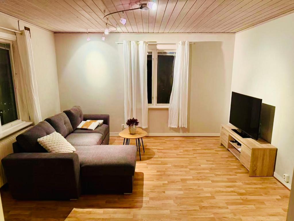 a living room with a couch and a flat screen tv at Homey Stay in Halmstad