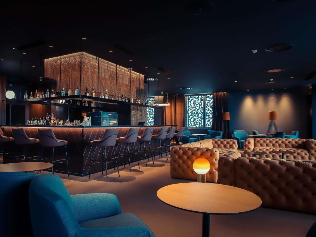 eine Bar mit Sofas und Stühlen und eine Bar mit einem Tresen in der Unterkunft Novotel Convention And Spa in Antananarivo