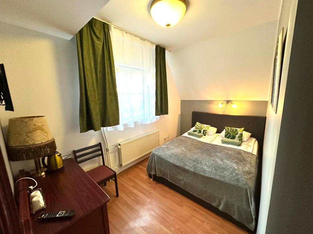 een slaapkamer met een bed, een bureau en een raam bij I&A Residence Humala in Tallinn
