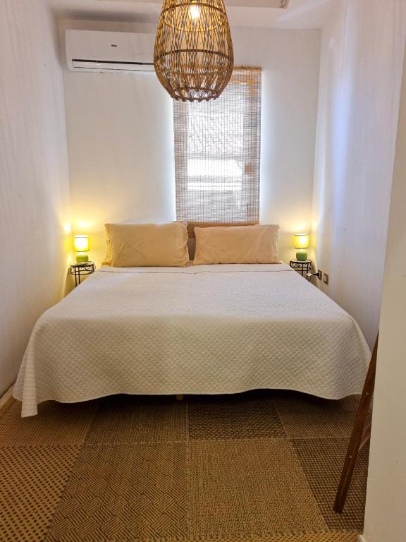 a bedroom with a large white bed with a chandelier at Casa Azzurra in Pizzo
