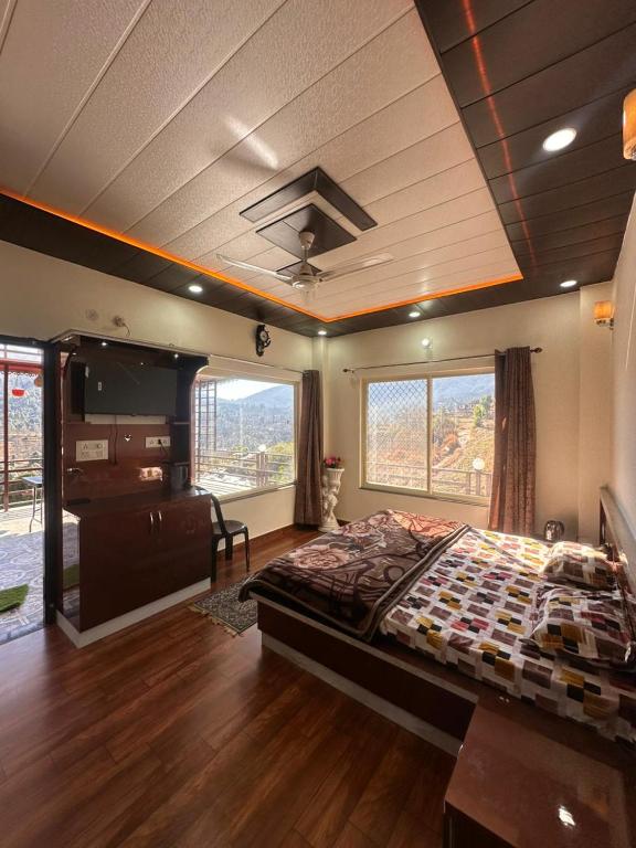 a bedroom with a large bed and a tv at Mount view guest house in Mukteshwar
