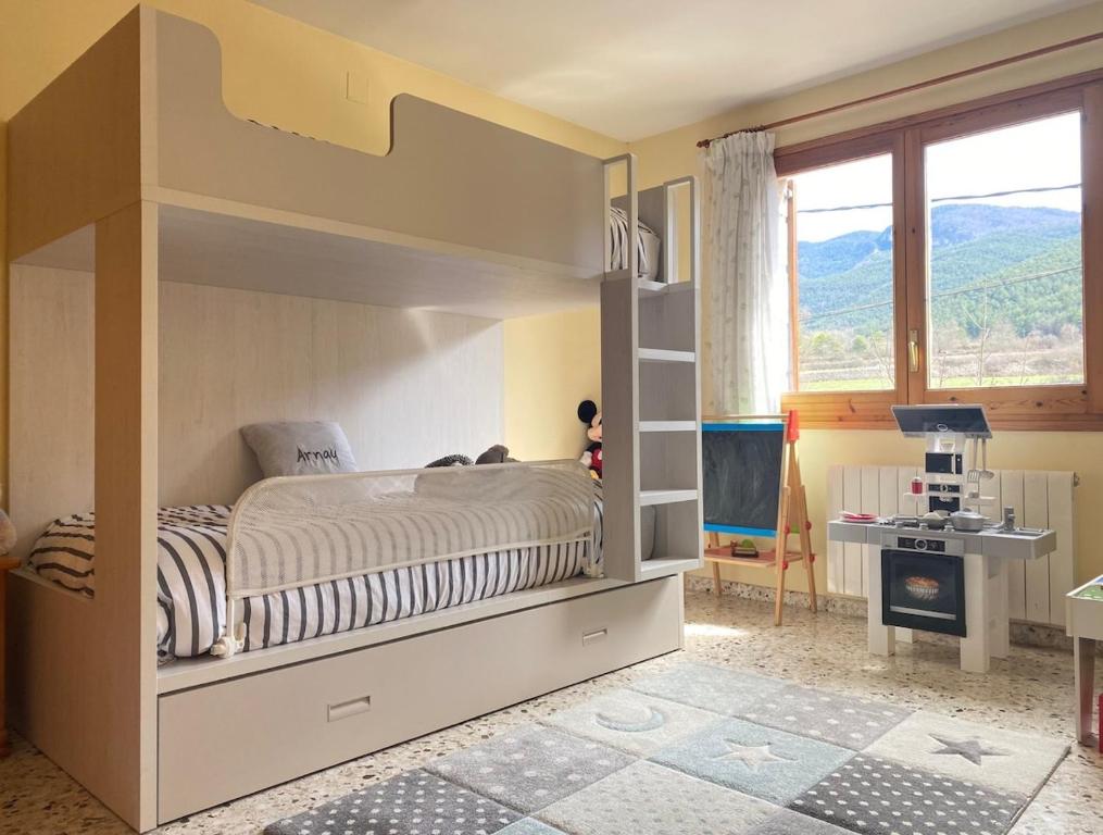 a childs bedroom with a bunk bed and a television at Casa de Muntanya per desconectar in San Julián de Cerdanyola
