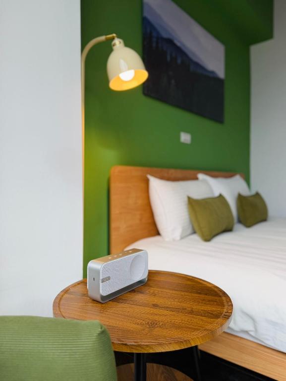 a bedroom with a bed and a table with a alarm clock at 吾庭文旅電梯民宿 WuTing Stay in Hualien City