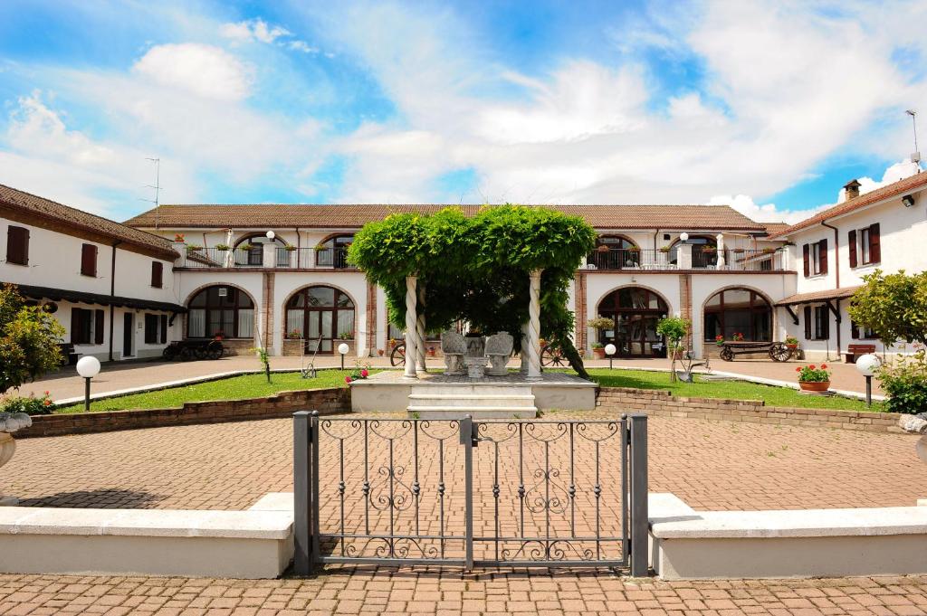 ein Tor vor einem Gebäude mit einem Brunnen in der Unterkunft Il Carrettino Country Hotel in Tortona