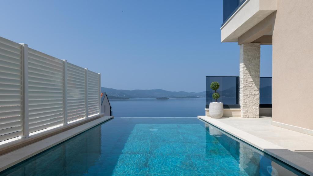 een zwembad in een huis met uitzicht op het water bij Villa Sole Komarna by Villas Guide in Klek