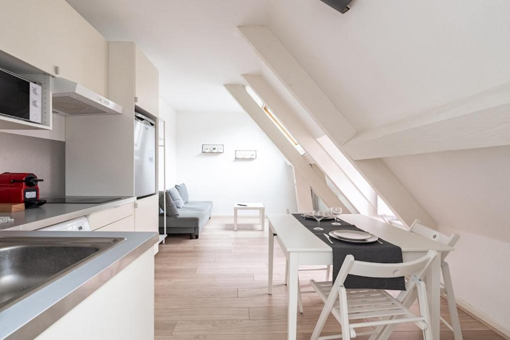 una cucina e una sala da pranzo con tavolo e sedie di Studio Hyper centre - Dans Hotel Particulier - Charles le Téméraire a La Celle-sous-Gouzon