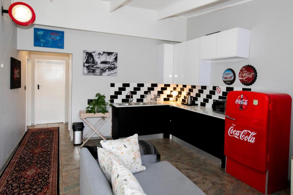 a living room with a couch and a red refrigerator at Buchan's Corner Unit 2 in Hartbeespoort