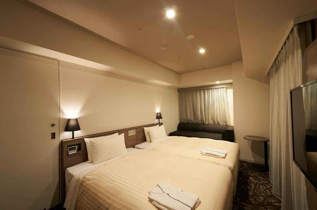 Postel nebo postele na pokoji v ubytování Sotetsu Fresa Inn Ginza-Nanachome