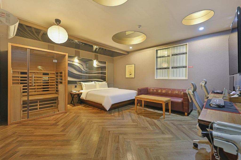 a hotel room with a bed and a couch at Palace Hotel in Ulsan