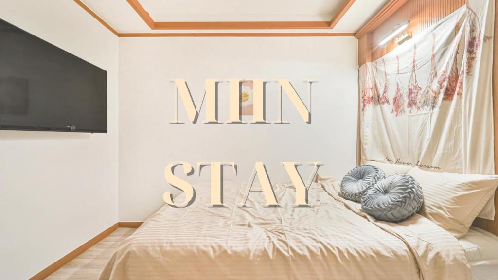 una camera da letto con un letto con un cartello sul muro di MIIN Stay a Seul
