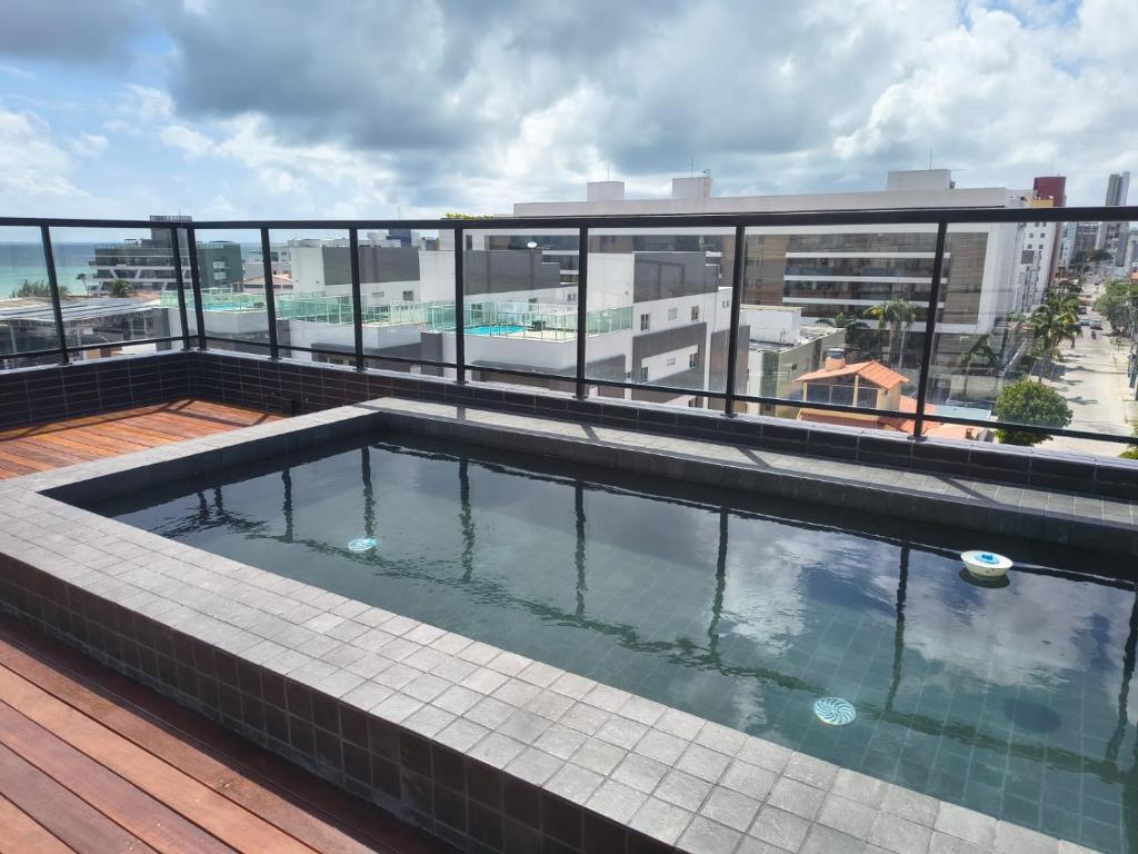 a swimming pool on the roof of a building at Flat espaçoso e estiloso na Praia do Bessa a uma quadra do mar! in João Pessoa
