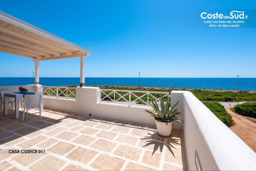 een balkon met een tafel en de oceaan op de achtergrond bij Residence Salento Fronte Mare in Torre San Giovanni Ugento