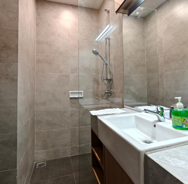een badkamer met een wastafel en een douche bij Saffron Noble Apartment in Citaringgul 1