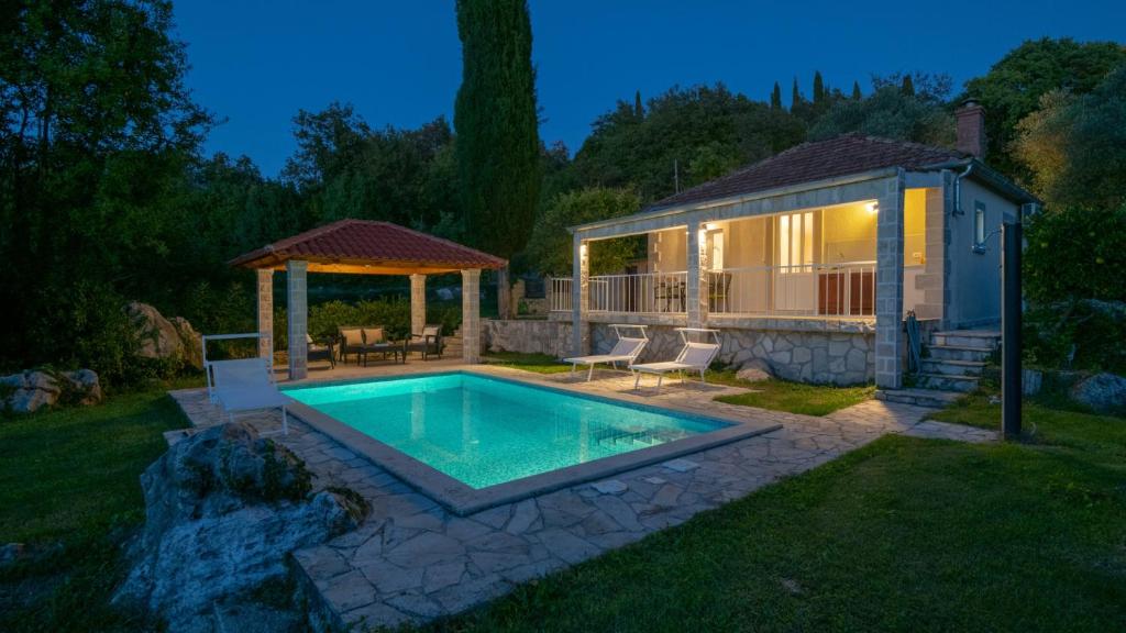 a backyard with a swimming pool and a gazebo at House Rilovic by Villas Guide in Srednji Radovčići
