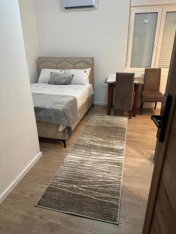een slaapkamer met een bed, een tafel en stoelen bij Happy moments Studio Kraljevo in Kraljevo