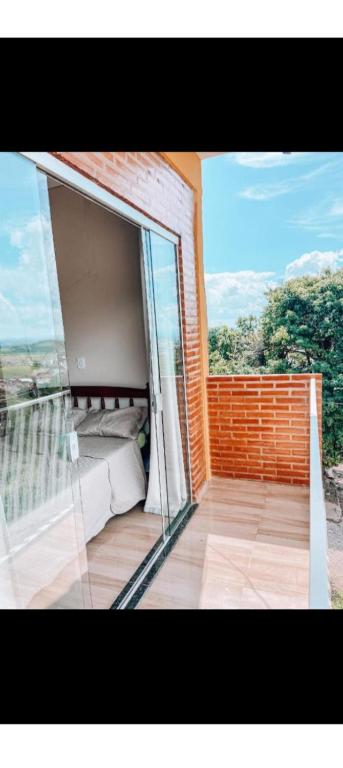 a room with a balcony with a bed and a window at Casa clima da montanha 1 in Cunha