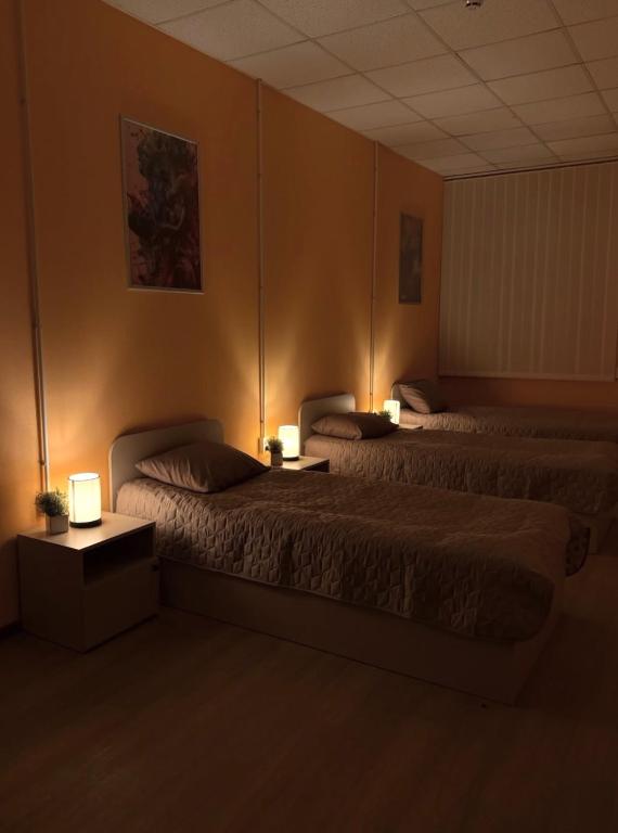 two beds in a room with two lamps on them at Трініті Хаус in Kyiv
