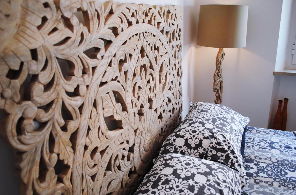 un letto con testiera in legno, cuscino e lampada di Festina Lente B&B a Porto Recanati