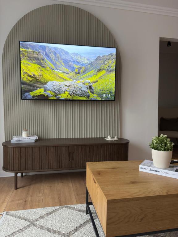 un soggiorno con una TV a schermo piatto su una parete di Cozy Central View a Reşiţa