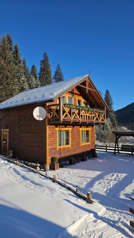 a log cabin in the snow with a porch at Котедж "Смерековий затишок" in Vorokhta