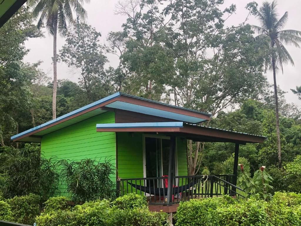 a small green house with a blue roof at Kohpu garden in Ban Klang