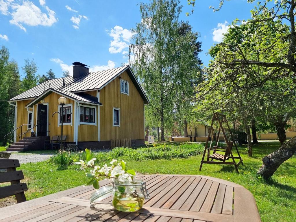 a small yellow house with a table in front of it at A little home in Lahti
