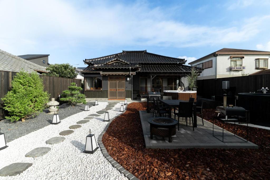 a patio with a table and chairs in front of a house at 陽和リトリート in Tateyama